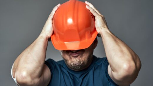 A stressed man in orange hardhat