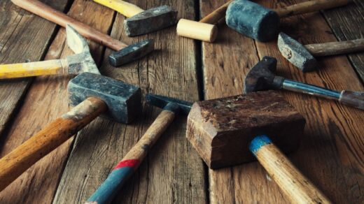 many hammers laid on a wooden table